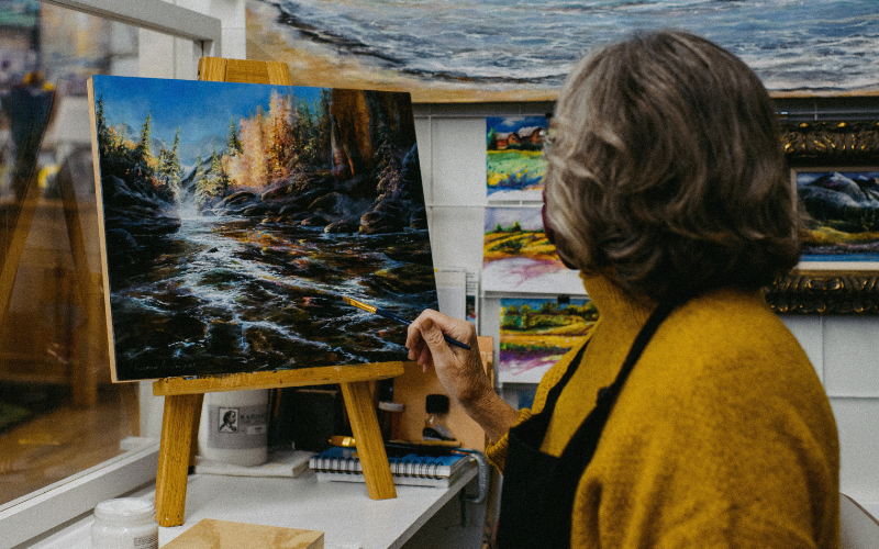 Artist painting a landscape of tree and river